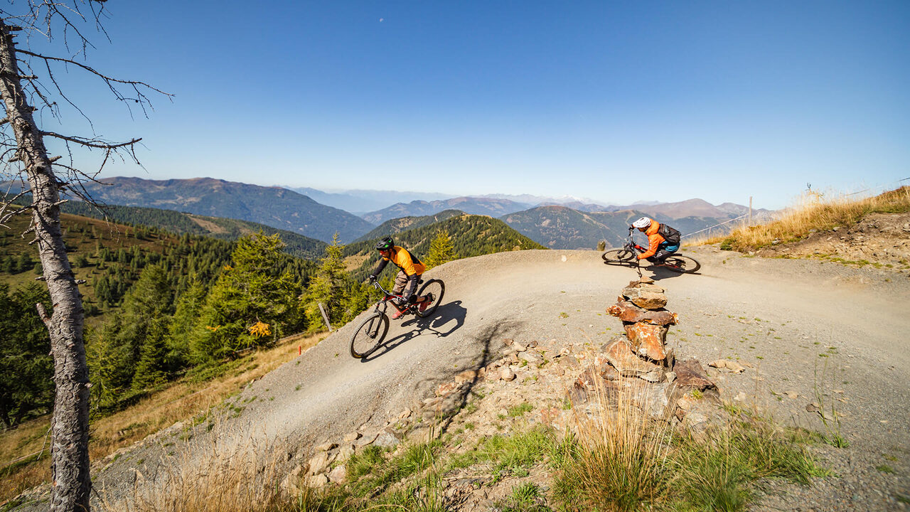 Mountain bikers on a gravel trail with mountain views