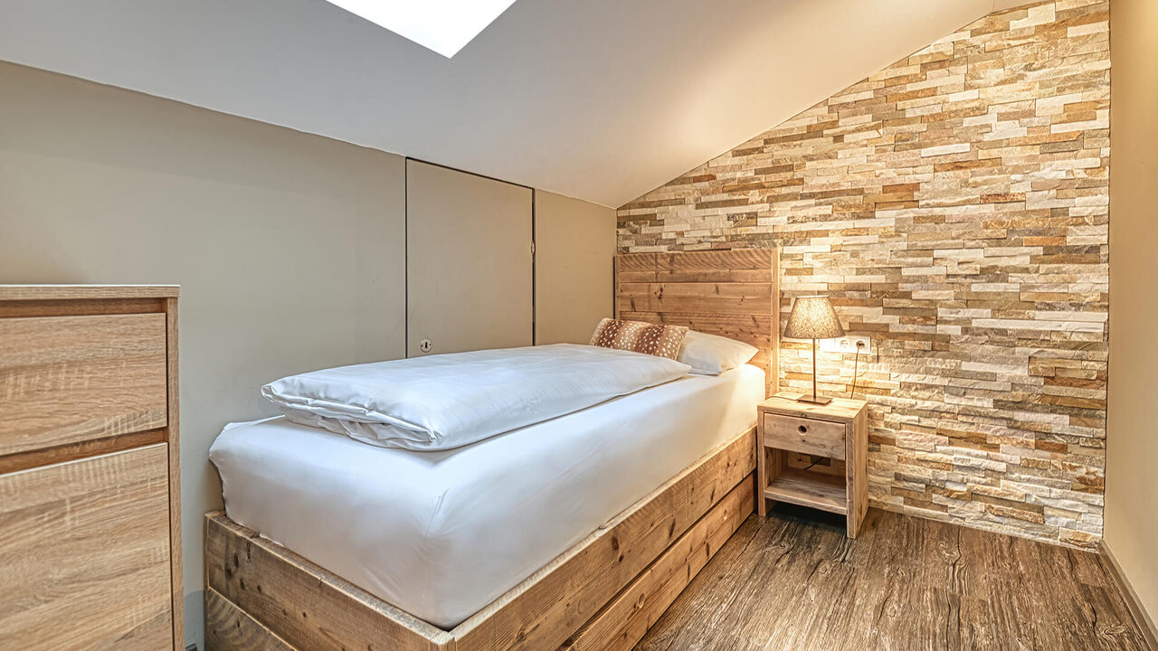 Einzelbett unter der Dachschräge im Apartment Hirschsprung