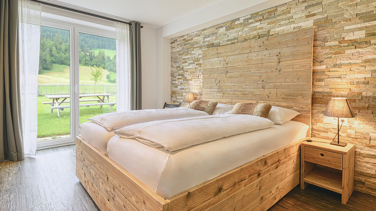 Schlafzimmer mit Doppelbett und Gartenzugang im Apartment Kaiserburg
