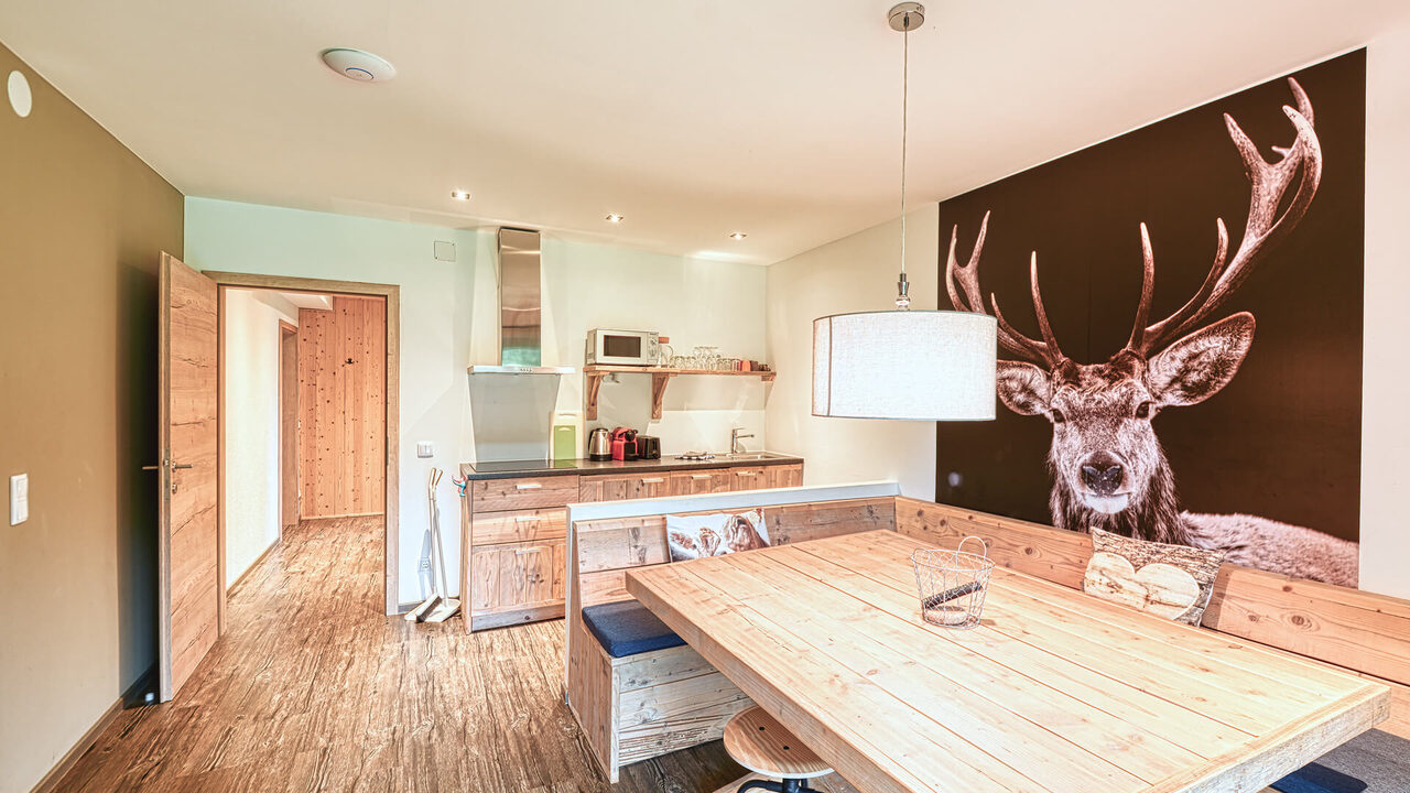 Küche und großer Esstisch mit Hirsch-Wandbild im Apartment Panorama