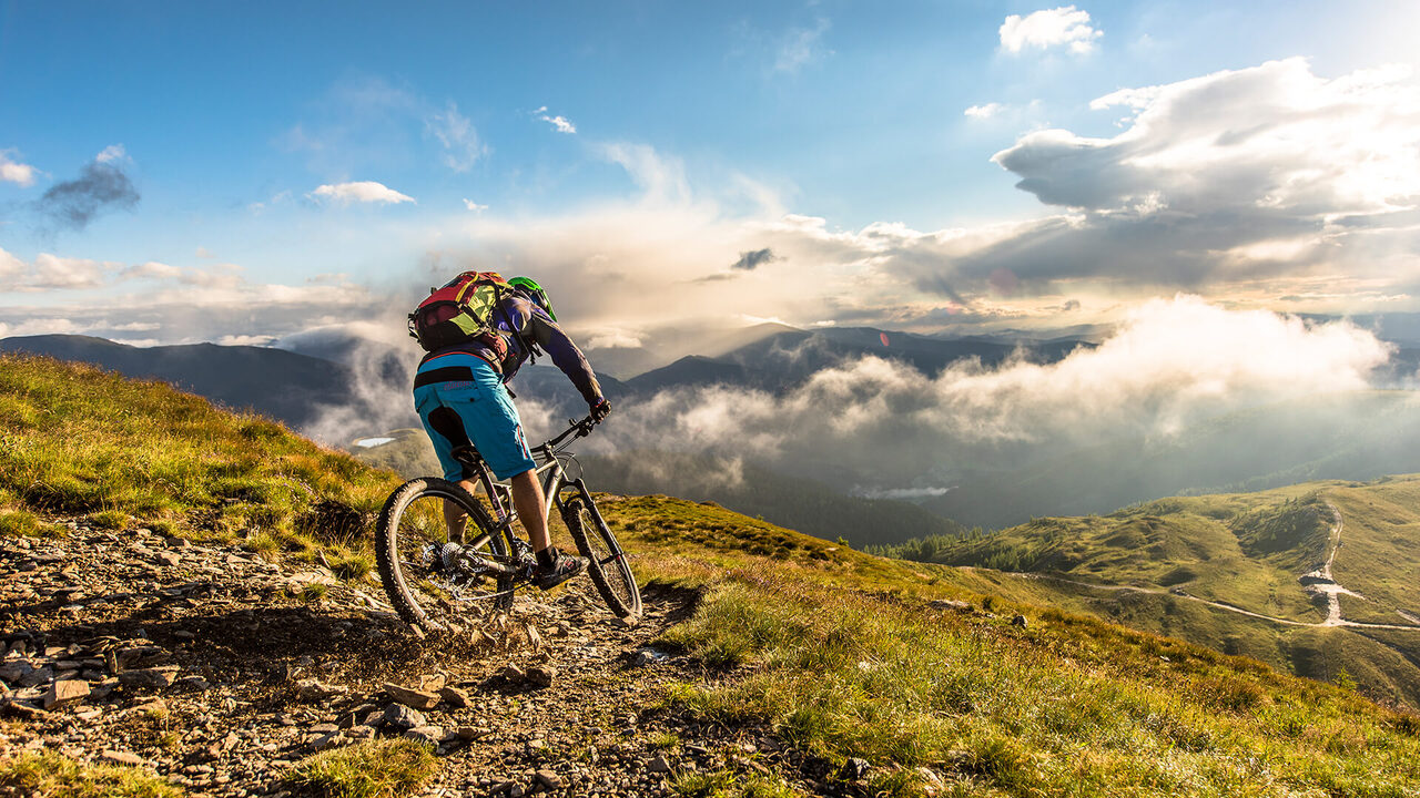Mountain biker su una cresta sopra un mare di nuvole