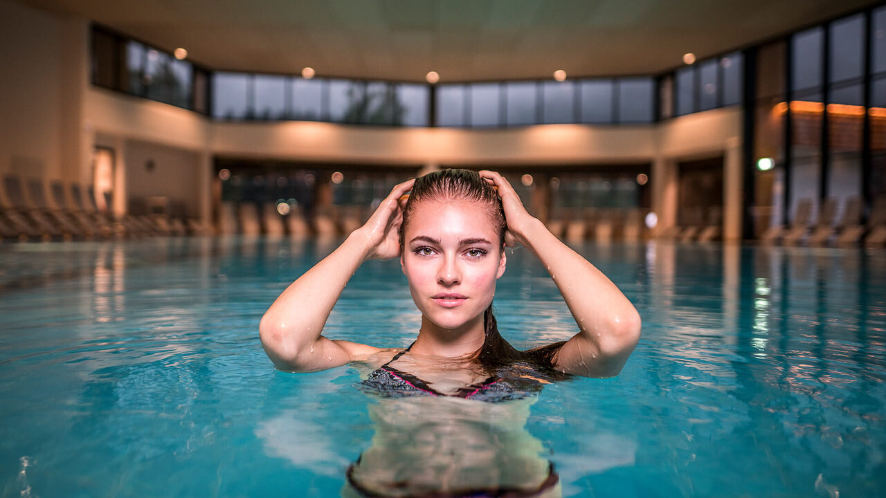 Donna nella piscina coperta di un centro termale