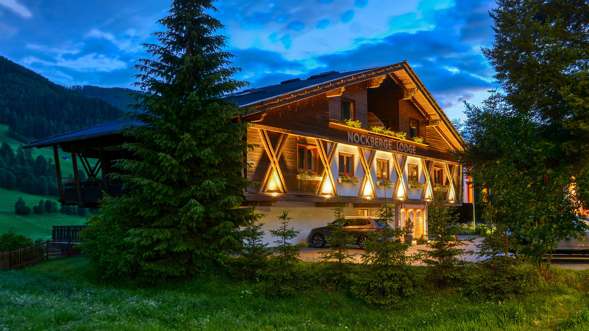 Die Nockberge Lodge im Chalet-Stil, abends beleuchtet