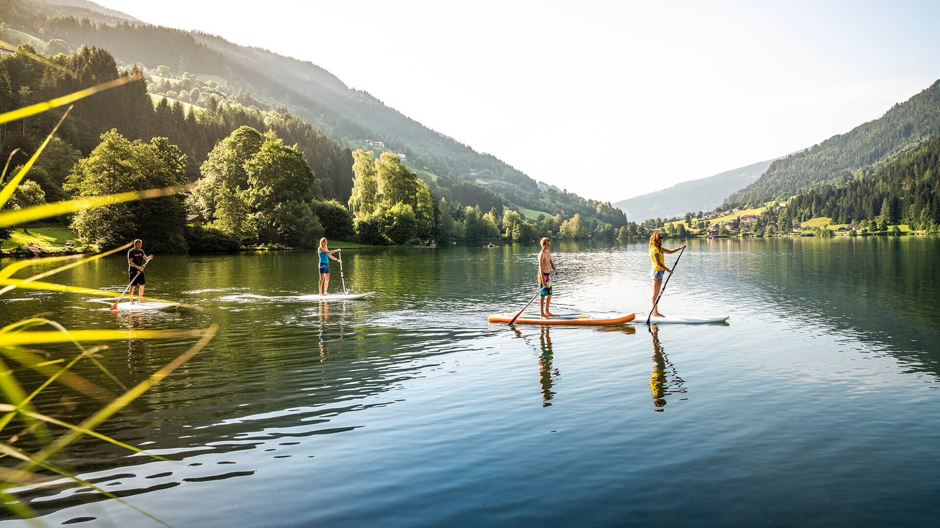 Praticanti di stand-up paddle su un lago di montagna