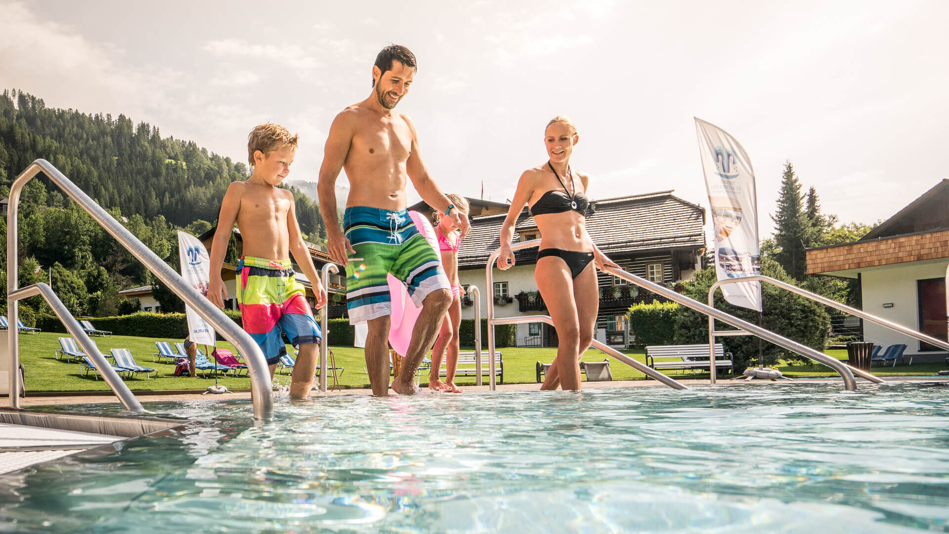 Famiglia che entra in una piscina termale all’aperto